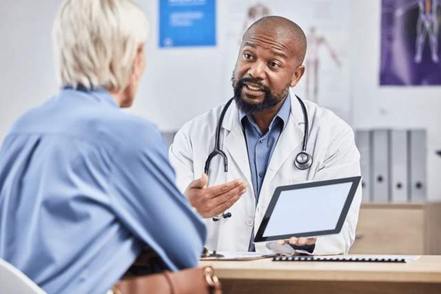 Doctor consulting patient with genetic information on screen