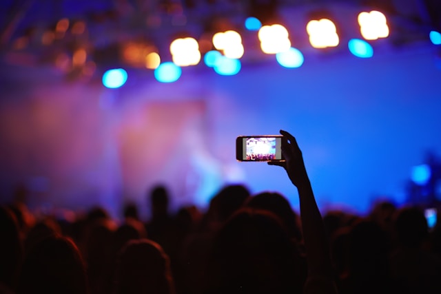 Person streaming video on a smartphone using 5G network at a concert